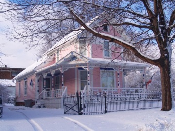 Pink and white Victorian house in winter snow